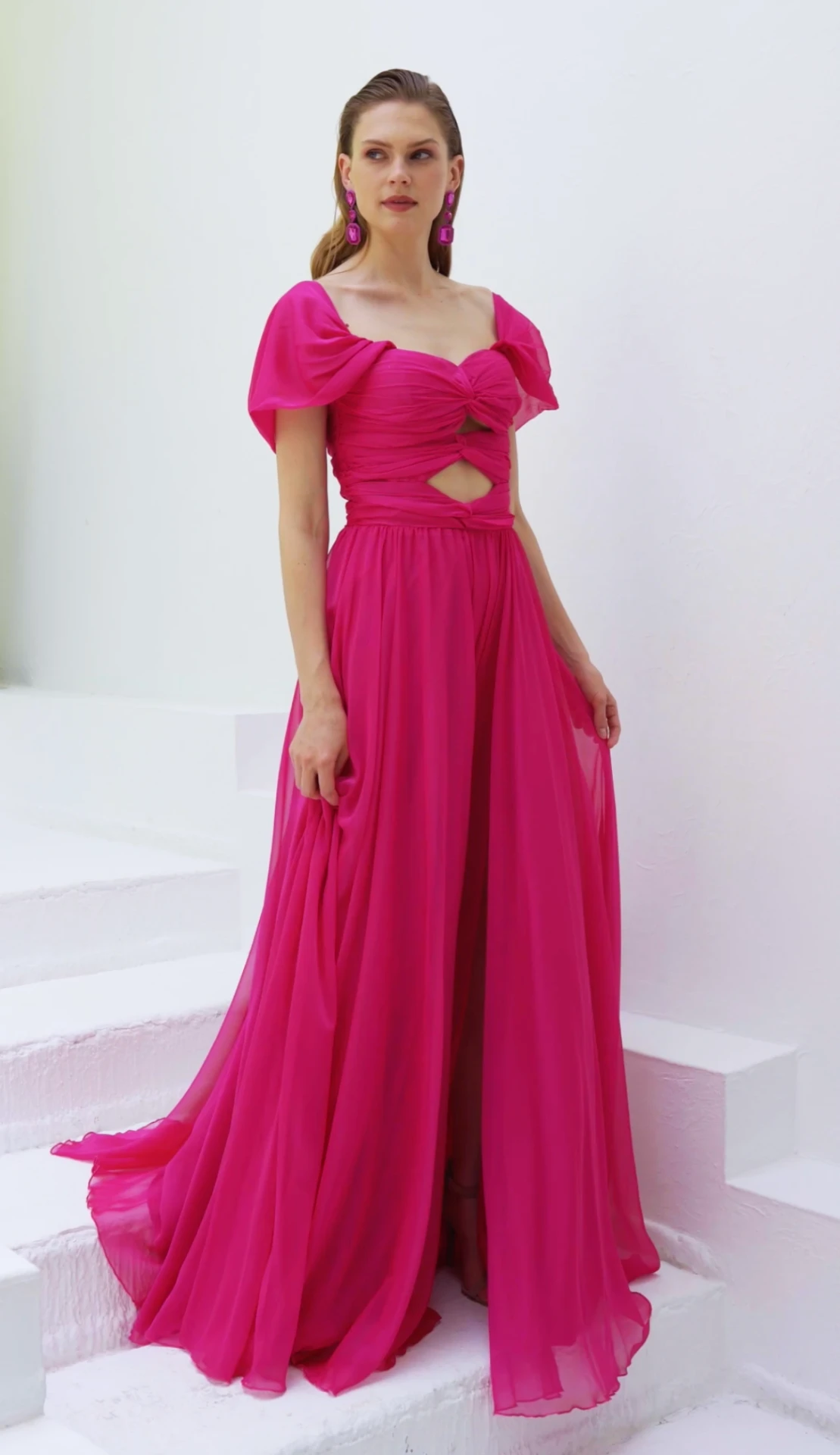 Fuchsia chiffon puff-sleeve gown with twisted cutout bodice and flowing skirt