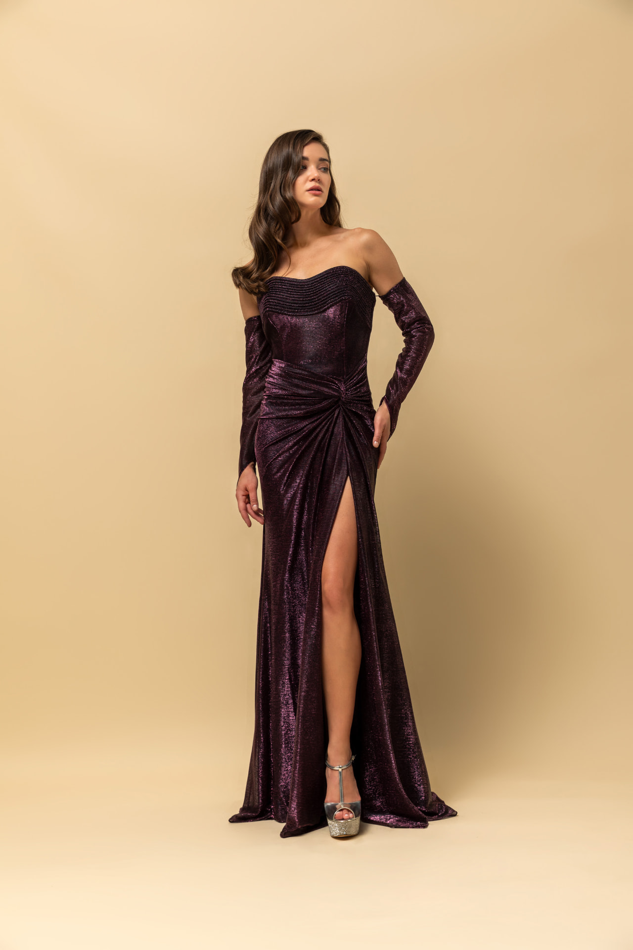 Plum metallic off-shoulder gown with long sleeves, knotted waist and high slit