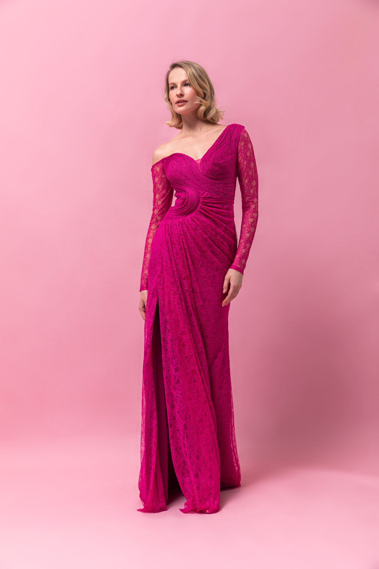 Fuchsia lace long-sleeve gown with asymmetric neckline and draped slit skirt